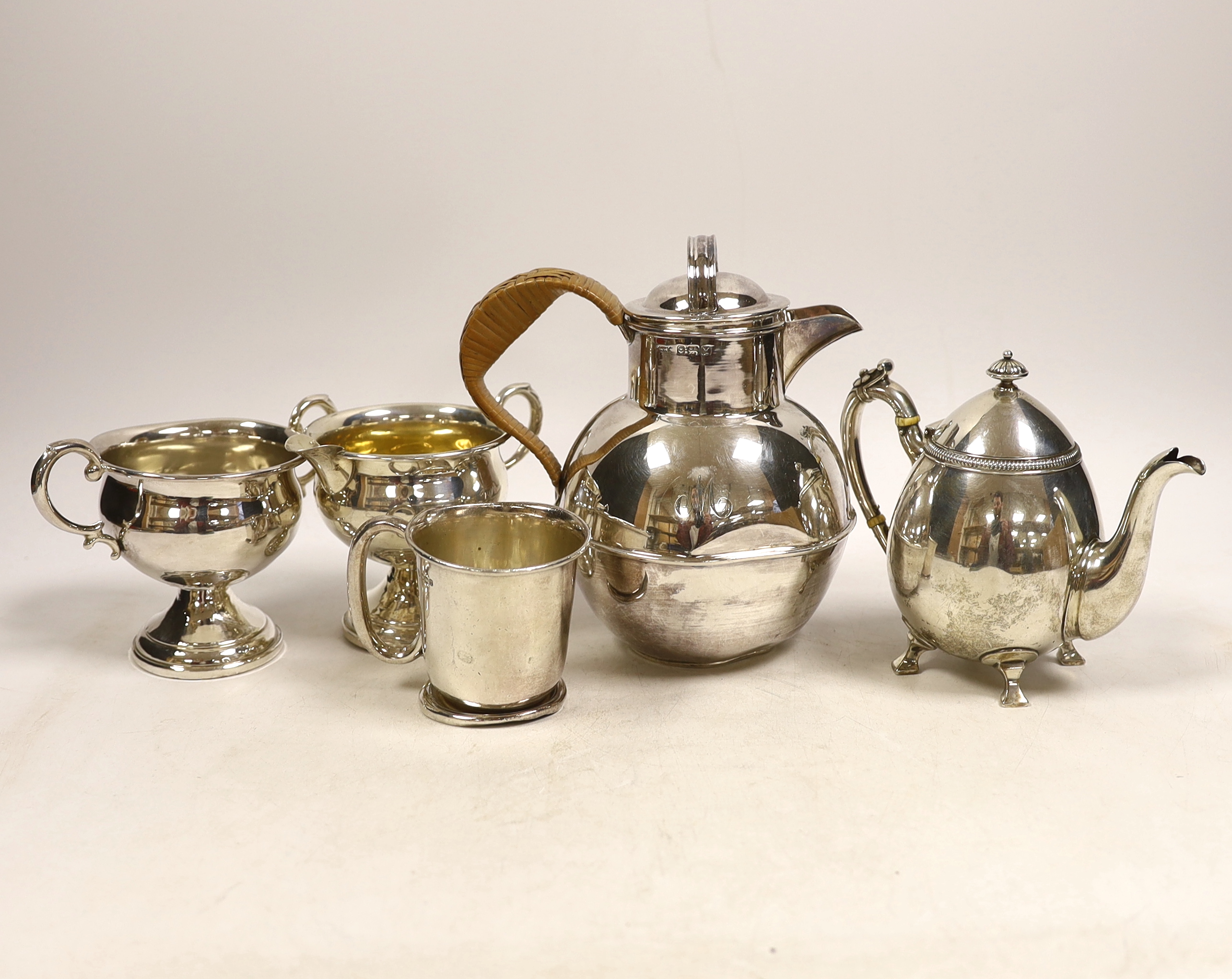 An Elizabeth II silver 'Guernsey' milk can, Kenneth Tyler Key, Birmingham, 1966, height 16.4cm, a sterling bachelor's teapot, sterling cream and sugar (weighted?) and a silver christening mug, gross weight 27.2oz. CITES